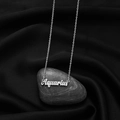 Silver Aquarius zodiac letter necklace on elegant black silk and stone background - Aquarius Steel