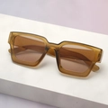Detail of trendy thick square tea-colored sunglasses on a minimalist white display - Light Tea Frame Tea Lens