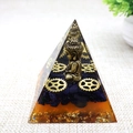 Detailed view of resin pyramid with gold Buddha statue, blue crystals and metal gears - Style 25