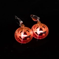 Close-up of glowing LED pumpkin earrings for Halloween with sparkling light effect - Pumpkin Clip-on Style / Orange Glowing