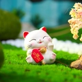 Cute white fortune cat resin ornament holding a red lucky sign in a garden setting - 120 Getting Richer Daily / Extra Large Tray Display Series