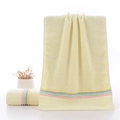 Light yellow cotton towel with colorful striped borders in hanging and folded display - Weak Twist Colorful Stripe Yellow / 34*74cm