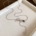 Détail du collier chaîne serpent argentée avec œil de tigre et perles en pierre tachetée - Style Rond