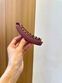 Matte brown 13cm banana hair clip for ponytail styling shown in a handheld view - Fuschia