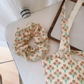 Dettaglio del tessuto in cotone con motivo floreale arancione vintage sulla borsa a spalla - Scrunchie