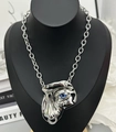 Macro shot of silver hip-hop face mask pendant with a striking blue eye on a cuban chain - Silver Necklace