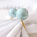 U-shaped turquoise napkin ring with twin faux pearls and gold finish on white fabric - Teal Blue