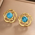 Macro shot of gold floral earrings with center turquoise stones and hollow petals - Gold/Deep Blue Turquoise (E-324)