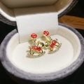 Vue macro de boucles d'oreilles cheval à bascule dorées avec émail rouge et strass - Cheval à Bascule Zircon Motif Rouge Doré (60#)