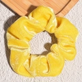 Detailed view of yellow velvet scrunchie showing soft fabric texture and pleated design - Yellow