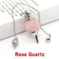 Pendentif pendule en quartz rose avec chaîne argentée posé sur un livre blanc - Pendentif avec chaîne ajourée / Quartz rose