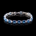 Detail of silver bracelet with square blue and round white zircons on black surface - Aqua