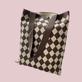 Detailed close-up of brown and beige checkered knit tote bag on a pink background - Diamond Khaki