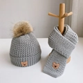 Detail of light grey knit hat and scarf set with pompom and cute bear patches - Bear Label Set / Gray