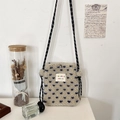 Detail of beige fleece crossbody bag with blue patterns and a colorful brand tag - Cream Blue Heart