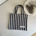 Detailed shot of black and white striped canvas tote with simple wish fabric label - Striped