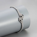Detailed close-up of a silver snake bracelet with white crystals and black gem eyes - White Gold with Black Eyes