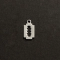 Primer plano detallado de un colgante de acero inoxidable plateado con forma de cuchilla - Color Acero