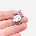 Gros plan détaillé du pendentif tortue en argent avec émail blanc et cristaux brillants - Argent Émail Blanc