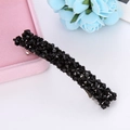 Dettaglio di perle di cristallo nero sfaccettato su un fermaglio per capelli in metallo - Nero