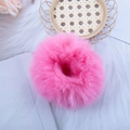 Chouchou en fausse fourrure de lapin rose sur un fond décoratif blanc élégant - Rouge pastèque
