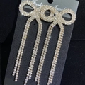 Elegant gold bow long tassel earrings with sparkling rhinestones on black card - Stud Earrings / Rose Gold