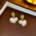 Detalle de pendientes vintage de perla corazón con marco dorado en estuche de lujo - Flor Dorada