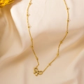Élégant collier en acier titane doré avec pendentif nœud évidé sur une chaîne à perles - Nœud