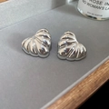 Macro detail of silver heart-shaped earrings with textured radial grooves on velvet tray - Heart / Silver