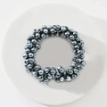 Detail of dark grey pearl elastic hair tie placed on a minimalist white circular tray - Dark Gray