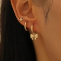 Three-piece golden bow earring set worn by a model showing detailed metallic luster - Gold Bow Earring Combination Set (WG-1122)