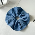 Vista detallada del coletero de tela vaquera azul con textura suave sobre fondo de madera - Azul Denim Claro Extragrande