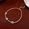 Dettaglio del bracciale a farfalla dorato con zirconi brillanti e chiusura regolabile - Oro