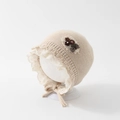 Vue détaillée du bonnet en tricot beige pour bébé avec dentelle et nœud fleuri à carreaux - 48cm (6-20 Mois) / Beige