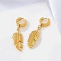 Macro detail of golden feather pendant earrings on white stone and silk background - Gold