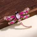Vintage dragonfly brooch with pink crystals and antique gold finish on wood background - Purple
