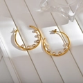 Detailed close-up of gold hoop earrings with seven sparkling round zircon stone settings - Gold White