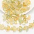 Detailed view of iridescent star and moon shaped glass beads for DIY jewelry making - Jelly Olive Green Orange