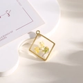 Ciondolo a rombo dorato con fiori secchi gialli e foglie verdi in resina chiara - Girasole giallo rombo