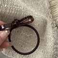 Close-up of hand holding dark brown acetate bow hair tie on textured fabric - Acetate Bow-Coffee