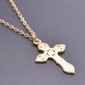 Detailed shot of golden stainless steel necklace with ornate cross pendant on grey texture - Gold Color + Necklace Chain