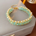 Dettaglio macro di cristalli verde menta e perle su un bracciale in acciaio vintage - Verde Menta