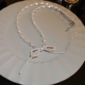Elegant white pearl necklace with a silver bow tie pendant and adjustable tassel chain - Silver White Bow Knot