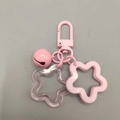 Close-up of pink star keychain with acrylic charms and a matching lacquered bell - Pink