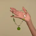 Détail d'un collier de perles avec un pendentif pomme verte et des perles de cœur - Coloré-Pomme