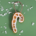 Handmade crochet candy cane ornament with orange and white stripes for Christmas decor - Alphabet