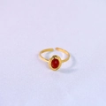 Macro shot of gold plated open ring featuring an oval red natural stone on purple fabric - Red Agate