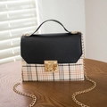 Vintage plaid crossbody bag with black pebbled flap and gold chain strap on wooden table - Black