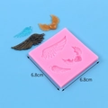 Detail of pink silicone wing mold with blue, bronze, and gold resin pendant samples - 50-357-A/Winged Heart / Pink