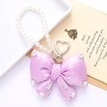 Detail of elegant purple satin bow keychain with sparkling rhinestones and white pearls - Purple